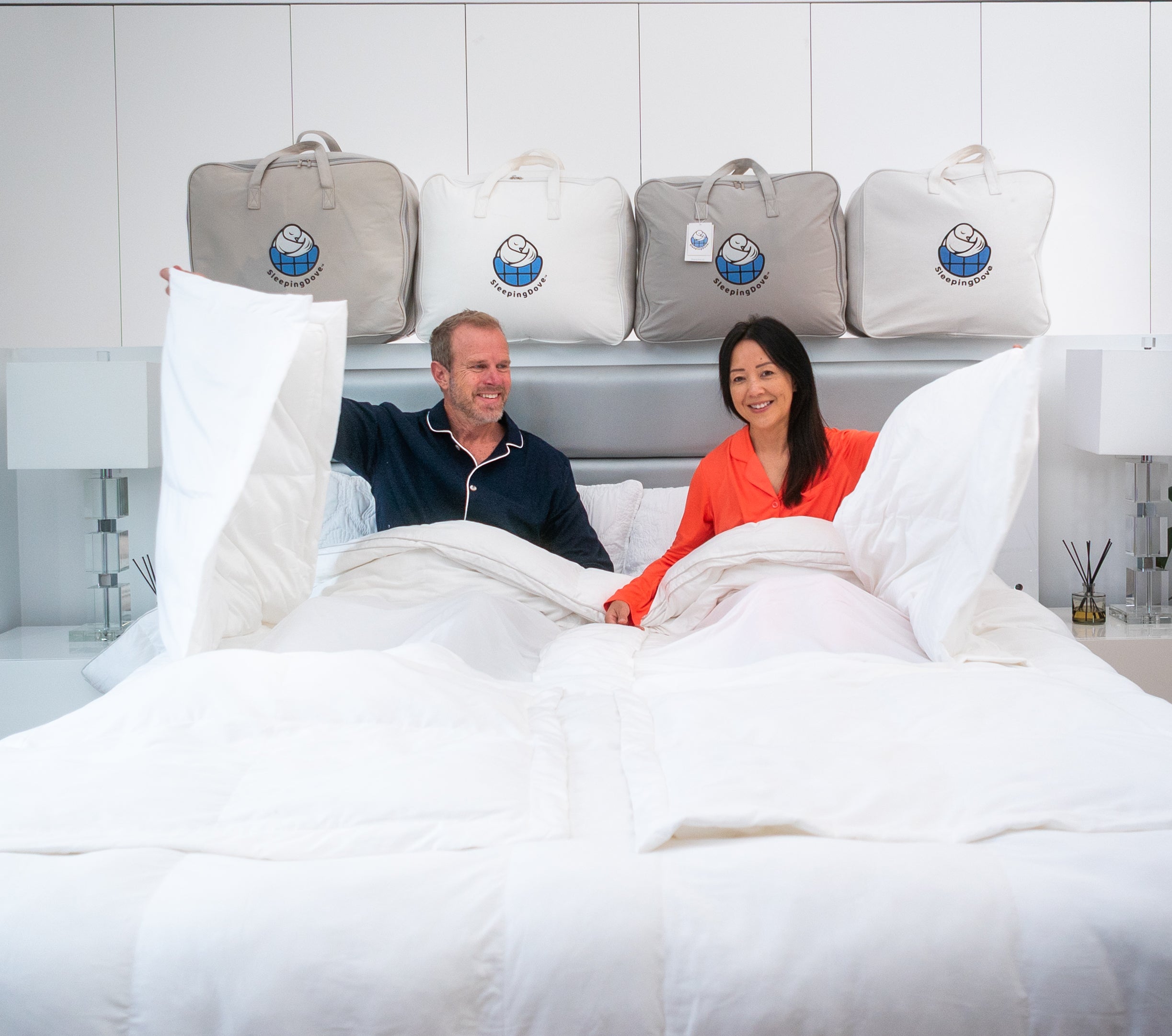 Man and woman in bed opening window panel in sleeping dove cooling comforter