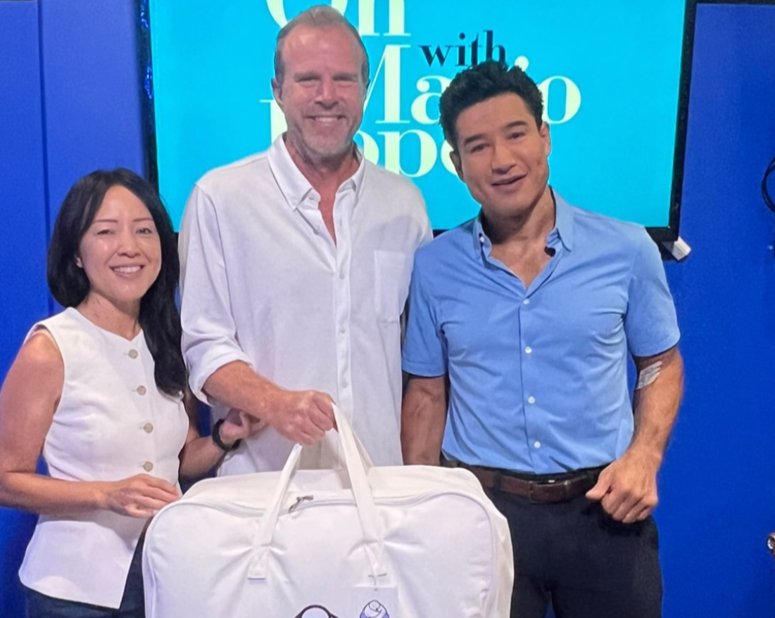 The founders of Sleeping Dove posing with Mario Lopez during an interview about the luxury cooling comforter with windows