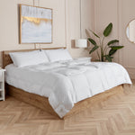 Neatly made bed with white sleeping dove cooling comforter all panels closed in a bedroom setting.