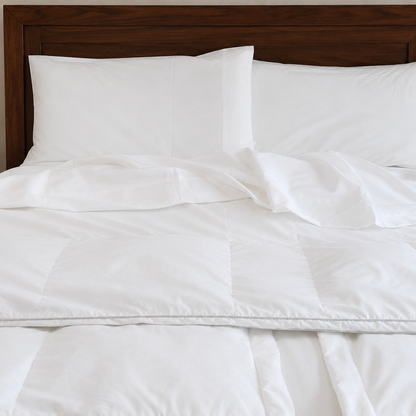 White sleeping dove bedding set with two white pillows and a dark wood headboard.