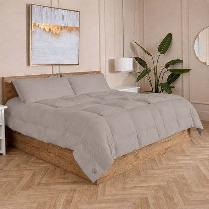 Stone Sleeping Dove cooling comforter set on a bed in a bedroom with wooden flooring and decor.