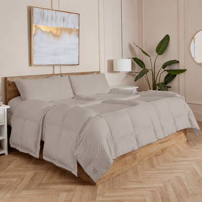 Stone Sleeping Dove cooling comforter set on a bed in a bedroom with wooden flooring and decor.