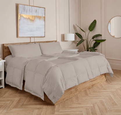 Stone Sleeping Dove cooling comforter set on a bed in a bedroom with wooden flooring and decor.