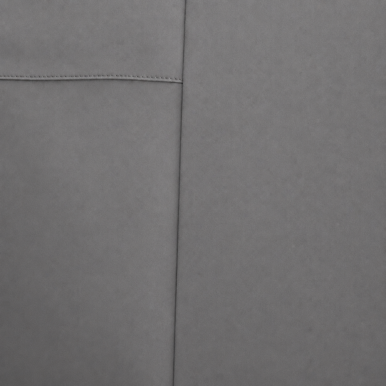 Close-up of a soft slate material surface with a visible seam and stitched detail.