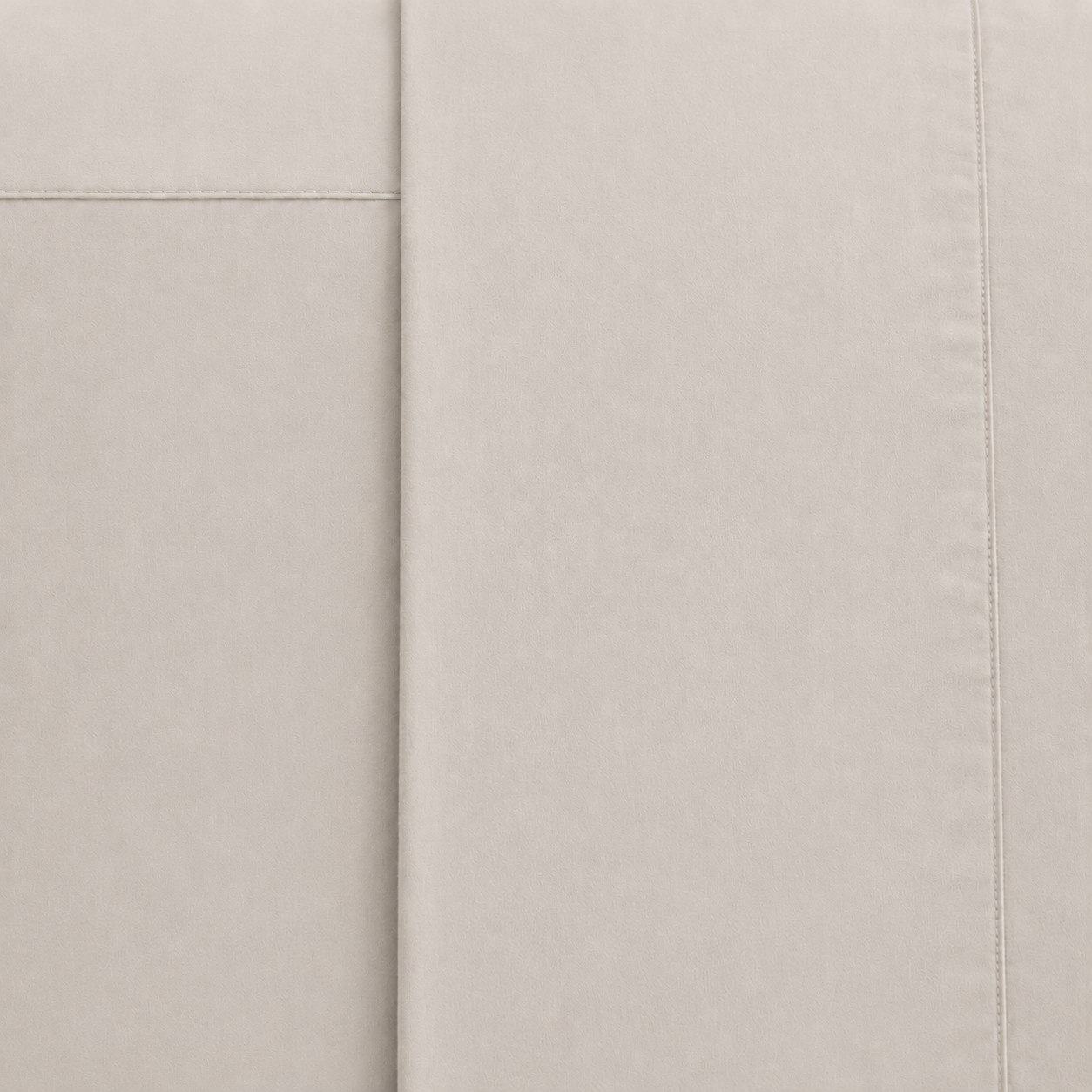 A close-up of a stone fabric surface with visible stitched panel seams and a fine woven texture.