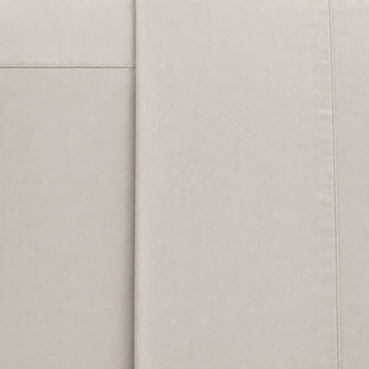 A close-up of a stone fabric surface with visible stitched panel seams and a fine woven texture.